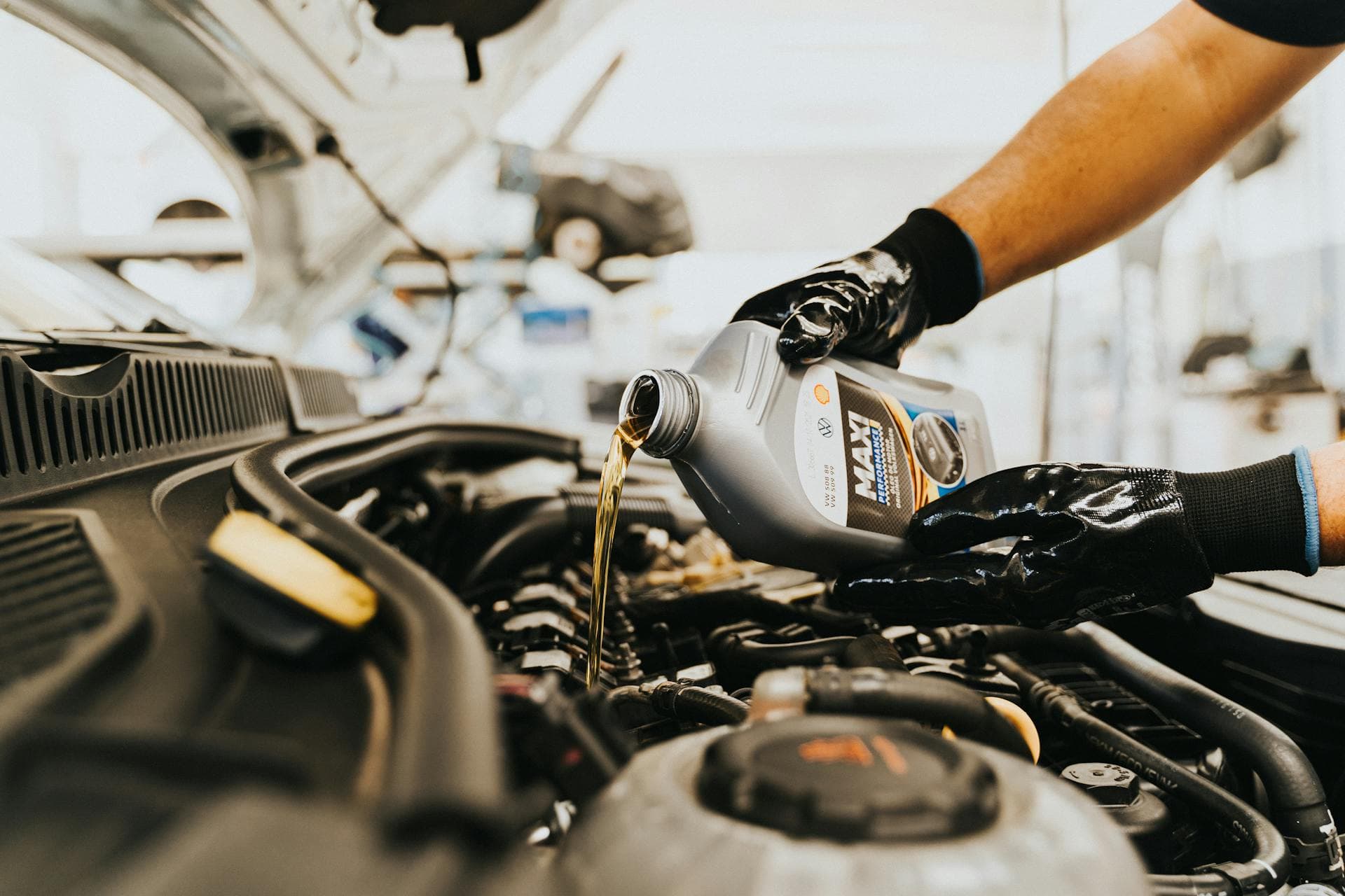 Verifica tagliandi auto: meccanico esegue il cambio olio presso un concessionario ufficiale
